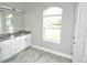 Elegant bathroom boasts a granite vanity and an arched window at 8233 Givlic Ln, North Port, FL 34287