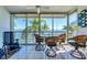 Bright sunroom features tile flooring, ceiling fan, and sliding glass doors with tranquil water views at 615 Dream Island Pl # 304, Longboat Key, FL 34228