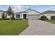 House exterior featuring a two-car garage and well-manicured lawn at 19642 Fort King Run, Brooksville, FL 34601