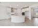 Bright kitchen featuring white cabinets, an island, and stainless steel appliances at 5307 Cappleman Loop, Brooksville, FL 34601