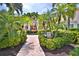 Building entrance with a walkway and tropical landscaping at 4264 Central Sarasota Pkwy # 116, Sarasota, FL 34238