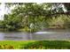 Scenic lake view with lush greenery and a fountain at 4264 Central Sarasota Pkwy # 116, Sarasota, FL 34238