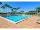 Inviting community pool with lounge chairs and palm trees at 5228 Landings Blvd # 202, Sarasota, FL 34231