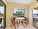 Cozy kitchen breakfast nook with glass table and wicker chairs at 5228 Landings Blvd # 202, Sarasota, FL 34231