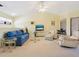 Open living room with vaulted ceiling, blue sofa, and recliner at 5228 Landings Blvd # 202, Sarasota, FL 34231