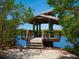 Relaxing waterfront gazebo with seating and a nearby bike at 5228 Landings Blvd # 202, Sarasota, FL 34231