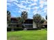 Two-story condo building with a red tile roof and palm trees at 3500 El Conquistador Pkwy # 142, Bradenton, FL 34210