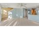 Bright living room showcasing tile floors, neutral paint, stairs, and a view into the kitchen at 5654 Simonton St, Bradenton, FL 34203
