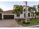 Two-story home with tile roof, palm trees, and a paved driveway at 531 Ranger Ln, Longboat Key, FL 34228