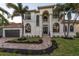 Beautiful two-story home with a grand entrance and lush landscaping at 531 Ranger Ln, Longboat Key, FL 34228