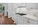 White kitchen with gas cooktop, stainless steel appliances, and quartz countertops at 531 Ranger Ln, Longboat Key, FL 34228