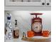 Wooden tray with mugs, clock, and liquor bottles on counter at 531 Ranger Ln, Longboat Key, FL 34228