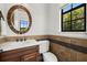 Elegant powder room with a wood vanity, updated fixtures, and earth-toned tile at 531 Ranger Ln, Longboat Key, FL 34228