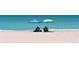 Couple relaxing on beach under umbrellas at 2383 Harbour Oaks Dr, Longboat Key, FL 34228