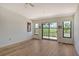 Bright bedroom with hardwood floors, sliding glass doors to balcony, and golf course views at 2383 Harbour Oaks Dr, Longboat Key, FL 34228