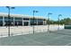 Tennis courts with spectator seating and modern clubhouse at 2383 Harbour Oaks Dr, Longboat Key, FL 34228