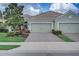 House exterior featuring a two-car garage and well-maintained landscaping at 4826 Maymont Park Cir, Bradenton, FL 34203