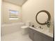 Modern bathroom with gray vanity and round mirror at 2163 Flagstaff Dr, Punta Gorda, FL 33983