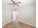 Simple bedroom with ceiling fan, wood-look floors, and an open door to hallway at 2479 Grandview Dr, North Port, FL 34288