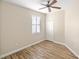 Well-lit bedroom with ceiling fan, wood-look floors, and a window with shutters at 2479 Grandview Dr, North Port, FL 34288