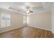 Main bedroom with wood floors, ceiling fan, and plantation shutters at 2479 Grandview Dr, North Port, FL 34288