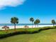 Beachfront property with lush landscaping and thatch umbrellas at 100 Sands Point Rd # 305, Longboat Key, FL 34228