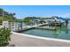 Community boat dock with several boats and green water at 100 Sands Point Rd # 305, Longboat Key, FL 34228