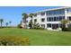 Building exterior with ocean views and manicured lawn at 100 Sands Point Rd # 305, Longboat Key, FL 34228