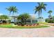Mid-century modern building with palm trees and brick pavers at 100 Sands Point Rd # 305, Longboat Key, FL 34228