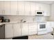 Modern white kitchen with stainless steel appliances at 100 Sands Point Rd # 305, Longboat Key, FL 34228