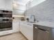 Modern kitchen with white cabinets and gray backsplash at 100 Sands Point Rd # 305, Longboat Key, FL 34228