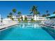 Inviting pool with palm trees and building reflection at 100 Sands Point Rd # 305, Longboat Key, FL 34228