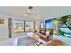 Living room boasts leather couches, tropical wall art, and a coffee table at 1415 Piedmont Rd, Venice, FL 34293