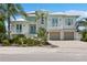 White two-story house with light teal accents, double garage, and lush landscaping at 149 Mckinley Dr, Sarasota, FL 34236