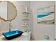 Stylish powder room with a unique blue sink and floating shelves at 149 Mckinley Dr, Sarasota, FL 34236