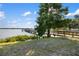 Scenic lakefront property with a wooden pier and lush landscaping at 6918 Grand Estuary Trl # 102, Bradenton, FL 34212