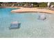 Relaxing pool area with in-water loungers and surrounding patio furniture at 6918 Grand Estuary Trl # 102, Bradenton, FL 34212