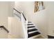 Modern dark wood staircase with white railings in a light-colored home at 6918 Grand Estuary Trl # 102, Bradenton, FL 34212