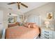 Bedroom with a white headboard bed, matching nightstands, ceiling fan, and a mirrored closet door at 6736 Fairview Ter # 6736, Bradenton, FL 34203