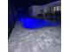 Blue-lit pool with gray stone pavers at night at 15504 Hennipen Cir, Port Charlotte, FL 33981