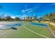 Outdoor basketball court with multiple hoops and a playground, set against a backdrop of lush landscaping at 1934 Mesic Hammock Way, Venice, FL 34292