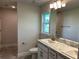 Bathroom with double vanity, granite countertops, and a walk-in shower at 2738 N Chamberlain Blvd, North Port, FL 34286
