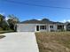 Newly constructed home with a white exterior, gray roof, and a two-car garage at 2738 N Chamberlain Blvd, North Port, FL 34286