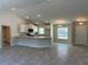 Open concept kitchen with white cabinets, granite countertops, and stainless steel appliances at 2738 N Chamberlain Blvd, North Port, FL 34286