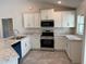 Modern kitchen with white cabinets, granite countertops, and stainless steel appliances at 2738 N Chamberlain Blvd, North Port, FL 34286
