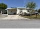 Front view of a manufactured home with a carport and ramp at 4906 Sea Island Ave, Sarasota, FL 34234