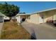 Tan single-wide mobile home with a carport and landscaping at 4906 Sea Island Ave, Sarasota, FL 34234