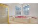 Bathroom with corner jacuzzi tub and gold-framed shower at 7430 Weeping Willow Dr, Sarasota, FL 34241