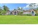 Single story home with manicured lawn and palm trees at 7430 Weeping Willow Dr, Sarasota, FL 34241