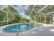 Inviting kidney-shaped pool with spa, screened enclosure, and lush landscaping at 7430 Weeping Willow Dr, Sarasota, FL 34241